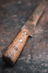 Old rustic handmade knife on the rustic background. Selective focus. Shallow depth of field. 