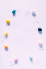 Colorful small eggs arranged in a circle egg shaped on a white background, holiday easter concept, with text happy easter.