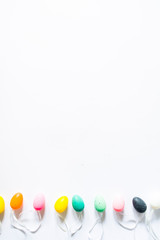 Colorful small eggs arranged in a circle egg shaped on a white background, holiday easter concept