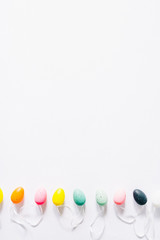 Colorful small eggs arranged in a circle egg shaped on a white background, holiday easter concept