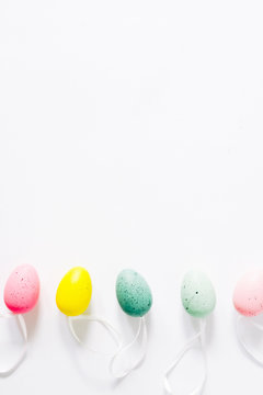Colorful small eggs arranged in a circle egg shaped on a white background, holiday easter concept