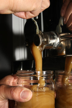 Bottling honey into glasses