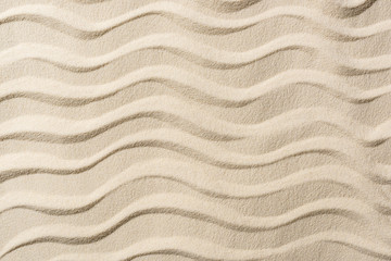 Fototapeta na wymiar top view of textured background with sand and smooth waves