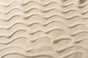 Fototapeta na wymiar top view of textured background with sand and smooth waves