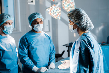 Obraz premium selective focus of doctors and nurse in uniforms and medical masks talking