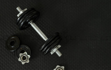 Plakat Top view of Iron dumbbells or weights on black floor with copy space for text. Flat lay composition. Health care concept.