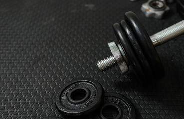 Plakat Iron dumbbells or weights on black floor with copy space for text. Health care concept.