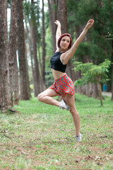 Happy redhead smiling girl dancing in a green park on Brazil in a summer day