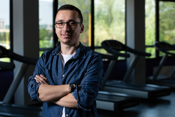 Weak Guy Nerd With Glasses In Fitness Center