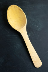 Wooden spoon with black textured background