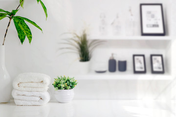 Mockup bath towels on wooden table in white room with copy space.