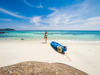 Fototapeta na wymiar woman with a kayak on an isolated beach in Andaman sea, Koh Lipe - solo travel