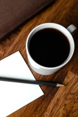 Black coffee in white cups by hand on wooden floors and coffee beans