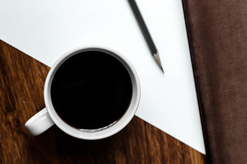 Black coffee in white cups by hand on wooden floors and coffee beans