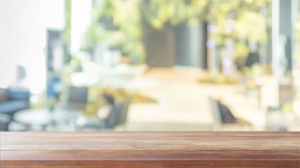 Empty wood table top and blurred bokeh cafe and restaurent interior background with vintage filter - can used for display or montage your products.