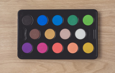 Watercolor palette on brown wood table. using for Arts and Education background