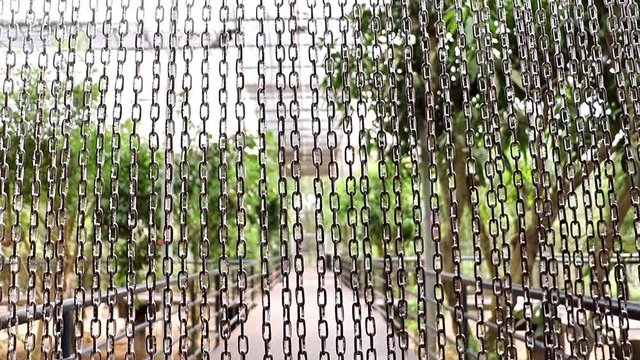 A line of steel chain protects entry to the aviary with tropical plants and exotics birds.