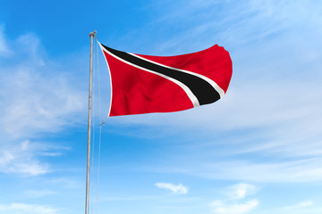 Naklejka na ściany i meble Trinidad and Tobago flag over blue sky background