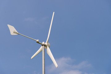 Small wind turbine on sky with cloud as background