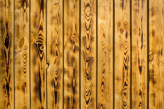 yellow brown fence wall of natural wooden boards. vertical lines. rough surface texture