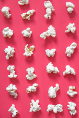 Tasty salted popcorn  on pink background. Flat lay of pop corn. Top view. Food, snack concept. Cinema snack. 
