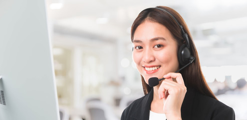 Asian Customer service operator woman with microphone headset working in call center contact office space background.Beautiful and smiling face.Telemarketing agent job concept.