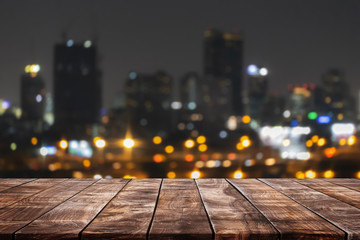 Empty wood table top on abstract blurred nightclub party with cityscape building lights background...