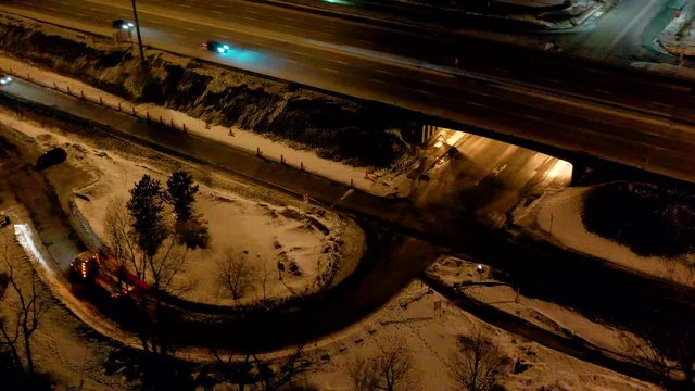 drone overlooking an interception in the middle of a busy highway at the beginning of the night