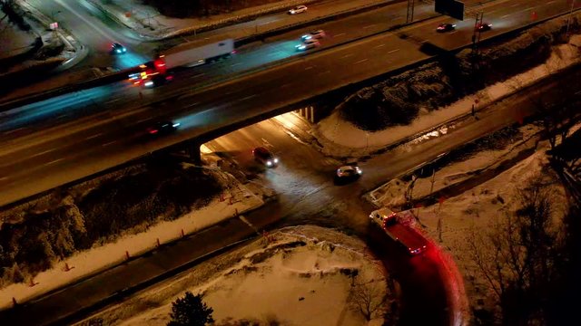 drone overlooking an interception in the middle of a highway at the beginning of the night