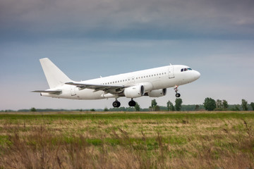 Fototapeta na wymiar White passenger jet plane in the air on take-off