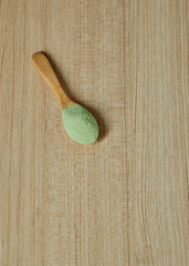 Fototapeta na wymiar Wooden spoon with powdered matcha green tea