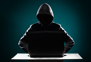 Computer hacker in hoodie. Obscured dark face. Data thief, internet fraud, darknet and cyber...