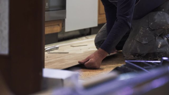 Handyman flooring tiles in an old kitchen. 4k