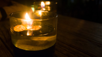 candles in a glass on a wooden table
