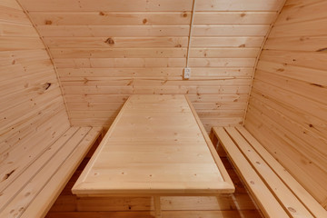 Fototapeta na wymiar interior of wooden bath in the form of a barrel. Rural mobile bath