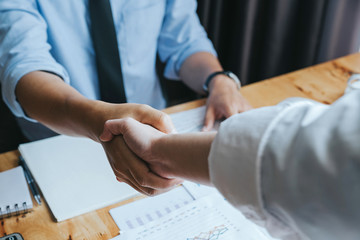  Close-up of two businessmen shaking hands during a meeting in the office, success, greeting and partner concept