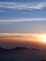 Sun set in Taiwans mountain region - Alishan mountain sun set in warm pastel colors with fog between mountain ranges