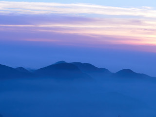 Fototapeta na wymiar Sun set in Taiwans mountain region - Alishan mountain sun set in warm pastel colors with fog between mountain ranges