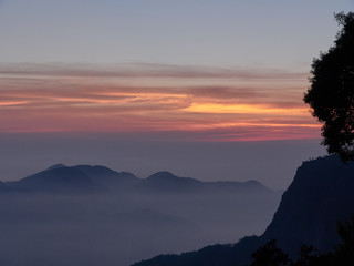 Sun set in Taiwans mountain region - Alishan mountain sun set in warm pastel colors with fog between mountain ranges