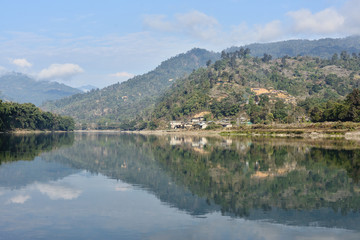 Fototapeta premium The view on the oxbow - Subansir river and hills with bamboo houses and the rainforest, Daparijo, Arunachal Pradesh, India