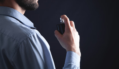 Man spraying perfume on his neck.