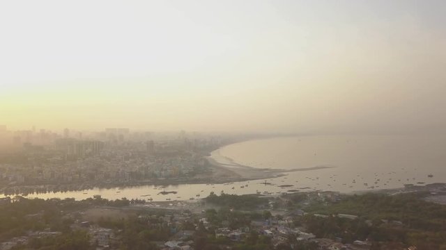A slow track in shot of Mumbai's coastline from Versova, Andheri. Covered by smog pollution in the early morning.