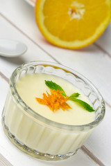 Panna cotta on white wood tray.