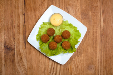 Deep fried cheese balls on the with dish with salad. Tasty dinner