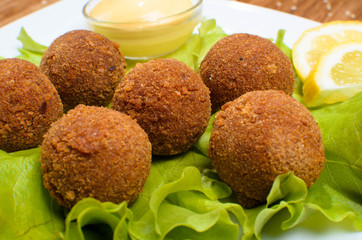 Deep fried cheese balls on the with dish with salad. Tasty dinner