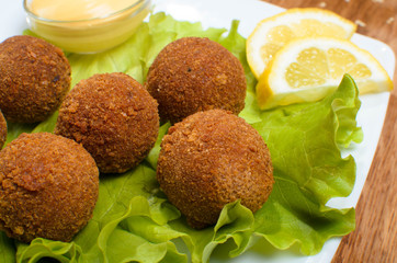 Deep fried cheese balls on the with dish with salad. Tasty dinner