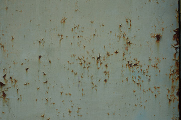 old rusty metal surface with cracked faded paint