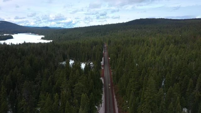 Winter scene of cars traveling on Oregon mountain pass highway; aerial footage