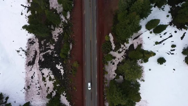 Top down view of Oregon mountain pass highway, white car traveling through