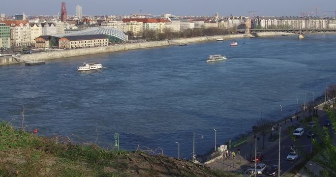 Ships cruise on the blue Danube river in Budapest in a spring afternoon.